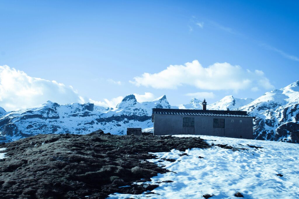 A serene winter landscape in Montagne, France, featuring snowcapped peaks and a solitary cabin.
